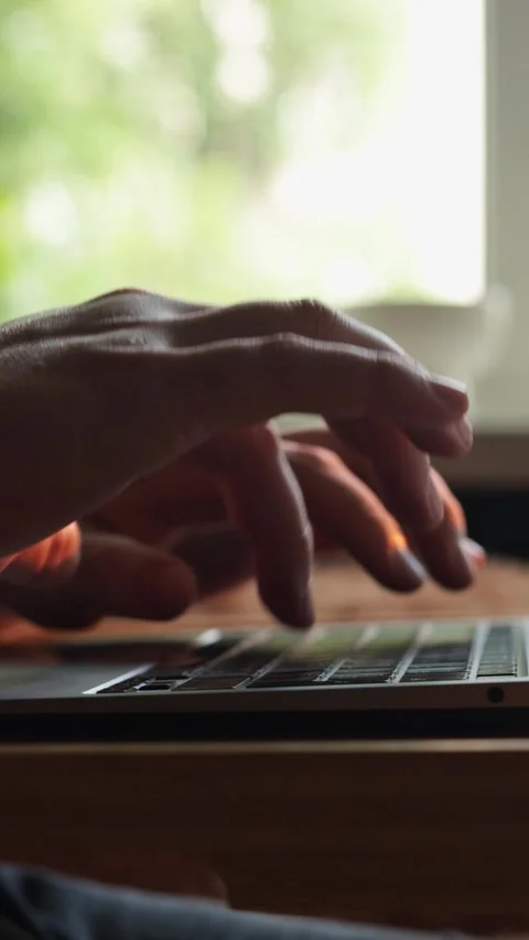 Close-up of hands typing on a laptop keyboard with a blurred natural background Stock-Footage 343838124