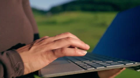Close-Up of Hands Typing on Laptop Outdoors 库存影片 339031614