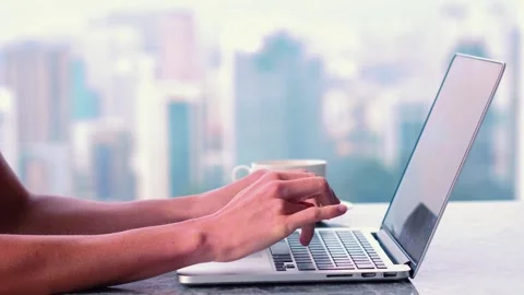 Close up of hands typing on laptop, panoramic window on a background Stock Footage 249985347