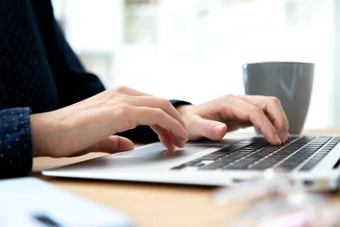 Close up of hands typing laptop. Selective focus on hands. Blurred background. Stock Photos