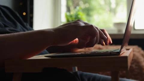 Close-up of hands typing on a laptop on a tray table by the window Stock Footage 340264348