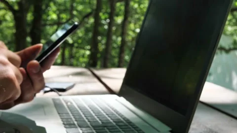 Close up of hands typing on laptops when phone rings and gets picked up by man Stock Footage 150079531