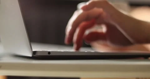 Close-up of hands typing quickly on a laptop keyboard, motion blur effect Stock Footage 339075635