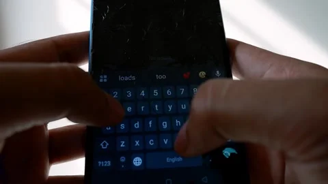Close-up of hands typing on a smartphone with a cracked screen Stock Footage 315981118
