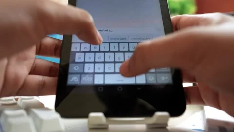 Close-up of hands typing on a tablet with an on-screen keyboard Stock Footage 316902038