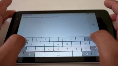 Close-up of hands typing on a tablet with an on-screen keyboard Stock Footage 318056793