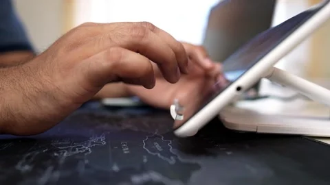 Close-up of hands typing on a tablet with a stand on a map Stock Footage 317737449
