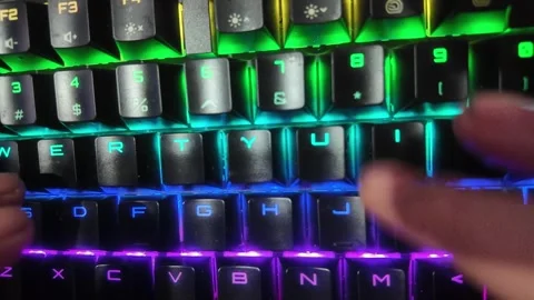 Close-up of hands typing on a vibrant RGB mechanical gaming keyboard,  focu.. Stock Footage 328340561