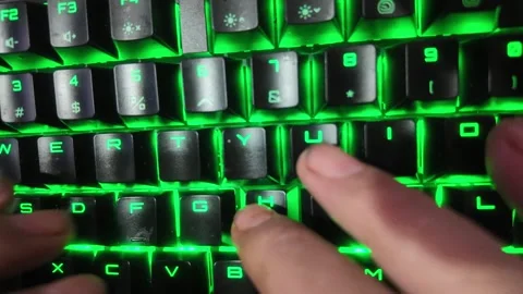 Close-up of hands typing on a vibrant RGB mechanical gaming keyboard,  focu.. Stock Footage 328340619
