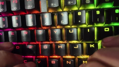 Close-up of hands typing on a vibrant RGB mechanical gaming keyboard,  focu.. Stock Footage 328847359