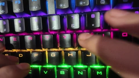 Close-up of hands typing on a vibrant RGB mechanical gaming keyboard,  focu.. Stock Footage 328847372