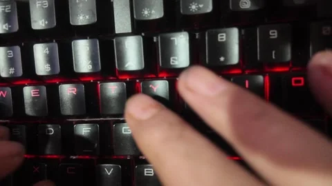 Close-up of hands typing on a vibrant RGB mechanical gaming keyboard,  focu.. Stock Footage 328847408