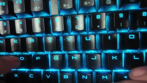 Close-up of hands typing on a vibrant RGB mechanical gaming keyboard,  focu.. Stock Footage 328847512