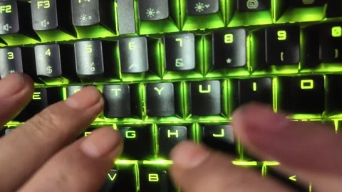 Close-up of hands typing on a vibrant RGB mechanical gaming keyboard,  focu.. Stock Footage 329139609