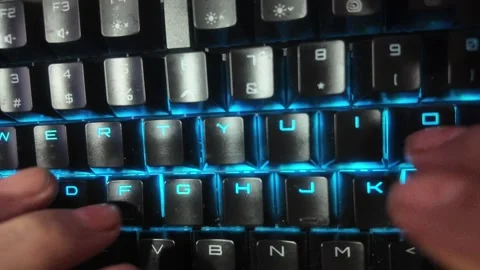 Close-up of hands typing on a vibrant RGB mechanical gaming keyboard,  focu.. Stock Footage 329139626