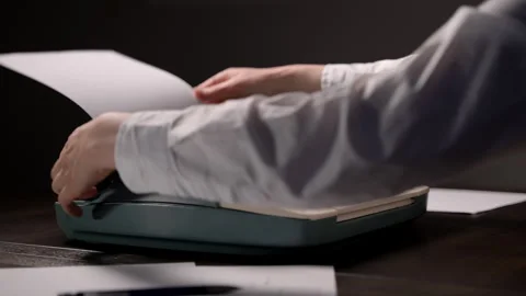 Close-up of hands typing on a vintage typewriter, inserting paper, adj Vidéo 326183789
