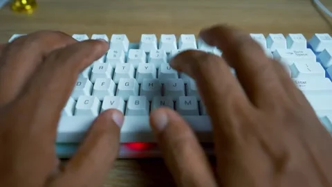 Close-up of hands typing on a white keyboard on a wooden desk Stock Footage 315981242