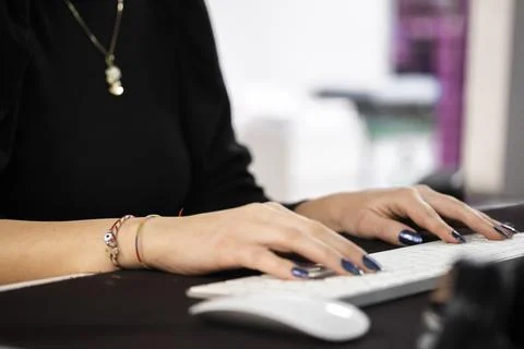 Close-up of hands typing on a white keyboard with a mouse in front Photos