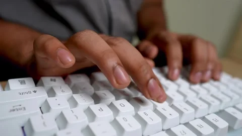 Close-up of hands typing on a white mechanical keyboard on a wooden desk Stock Footage 315982061