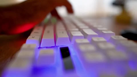 Close-up of hands typing on a white mechanical keyboard on a wooden desk 스톡 동영상 315982086