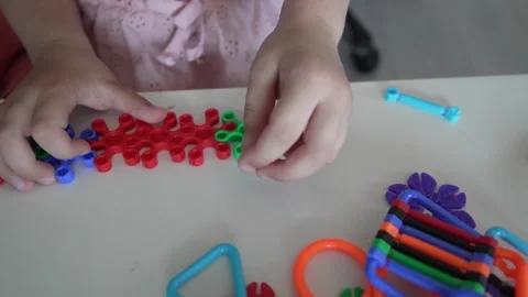 Close up on hands of unknown child play with Interlocking plastic toys Stock Footage 247022069