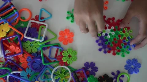 Close up on hands of unknown child play with Interlocking plastic toys Stock Footage 247022094