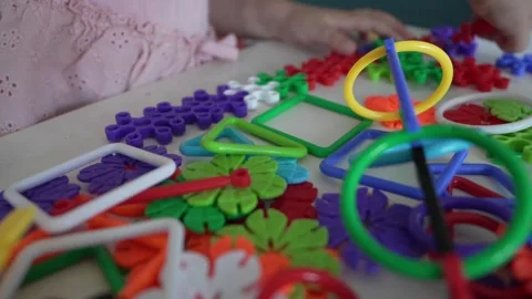 Close up on hands of unknown child play with Interlocking plastic toys Stock Footage 247022187