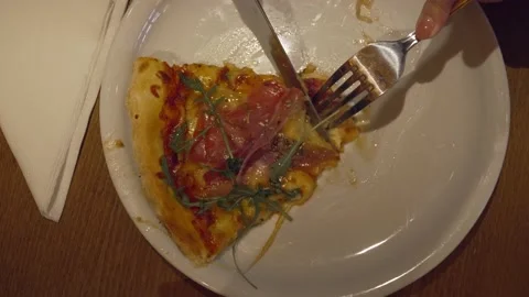 Close up of hands of unknown woman slice piece of pizza cut in the plate eati Stock Footage 221456266