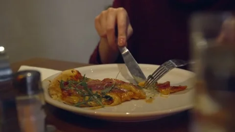 Close up of hands of unknown woman slice piece of pizza cut in the plate eati Stock Footage 221456291