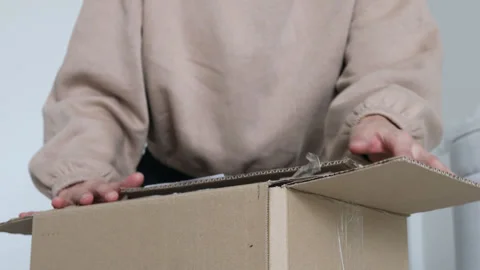 Close up hands unpacking a parcel, looking inside the open a cardboard box Stock Footage 255590359