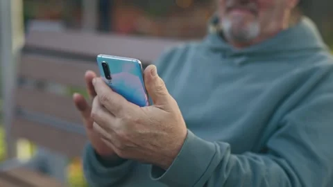 Close-up of the hands of an unrecognisable elderly man who is using a smartphone Stock Footage 255714874