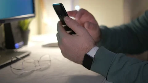 Close-up hands of unrecognizable businessman using mobile phone sitting at desk Stock Footage 235341406