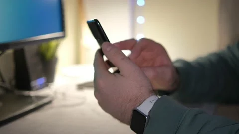 Close-up hands of unrecognizable businessman using mobile phone sitting at desk Stock Footage 236456460