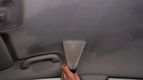 Close-up hands of unrecognizable car detailer using vacuum cleaner to clean Stock Footage 291334591