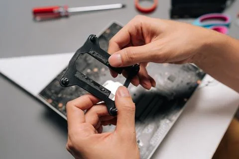 Close-up hands of unrecognizable computer technician mounting CPU cooler bracket Stock Photos