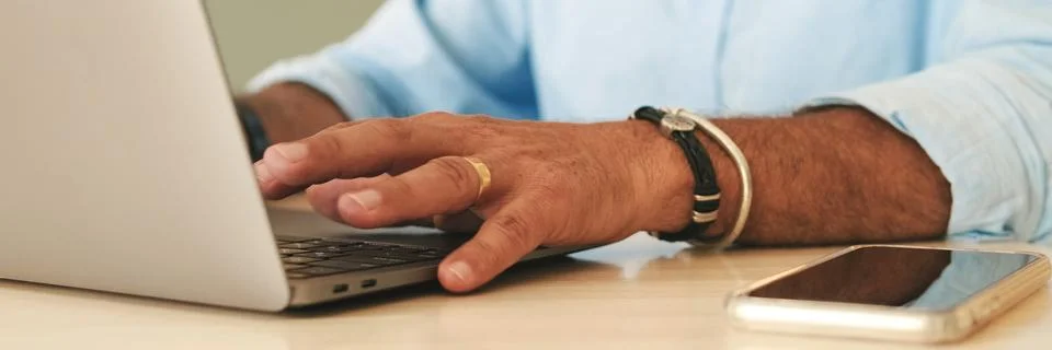 Close-up of hands of an unrecognizable elderly man working on laptop Stock Photos