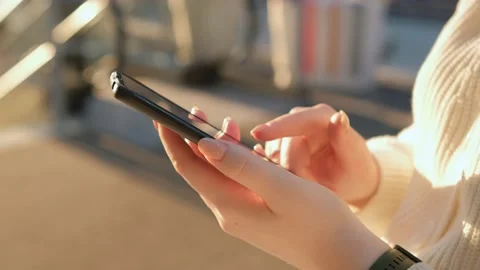 Close-up hands of unrecognizable female shopper using smartphone standing in Stock Footage 236190211