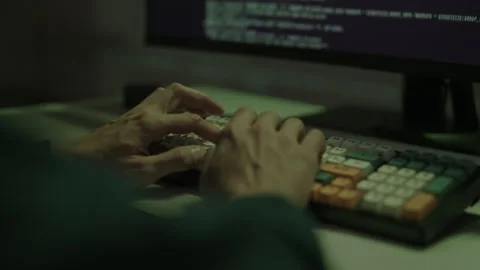 Close-up hands of unrecognizable hacker typing on computer keyboard with Stock Footage 321685661