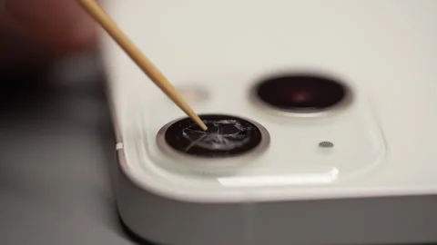Close-up hands of unrecognizable man cleaning broken lens on mobile phone using Stock Footage 265163508