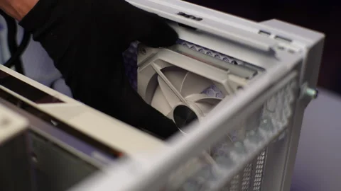 Close-up hands of unrecognizable man in gloves installing new fan in system unit Stock Footage 271298571