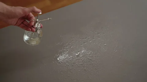 Close-up hands of unrecognizable man holding glass spray bottle, releasing fine Stock Footage 312328626