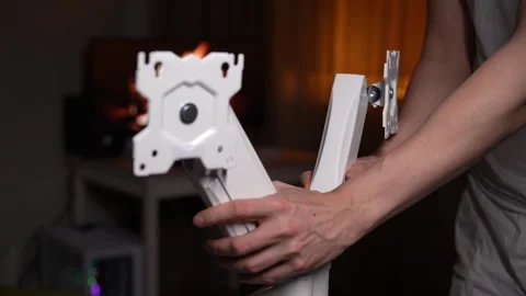Close-up hands of unrecognizable man installing white dual monitor stand on Stock Footage 297633021