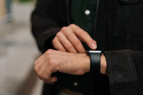 Close-up hands of unrecognizable man interacting with smartwatch, checking time Stock Photos