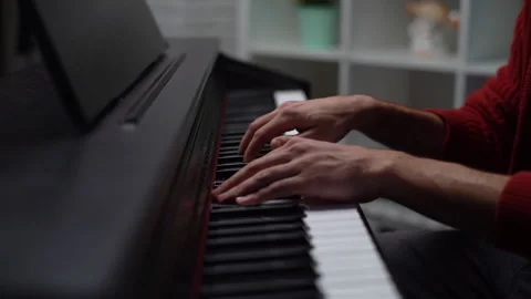 Close-up hands of unrecognizable man playing on digital piano at home recording Stock Footage 150040573