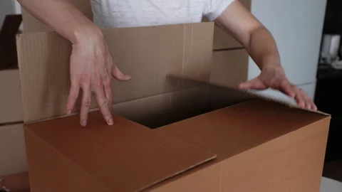 Close-up hands of unrecognizable man putting together big cardboard box for Stock Footage 267641359