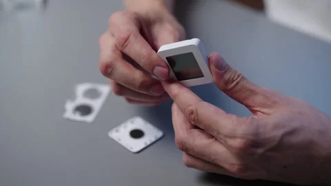 Close-up hands of unrecognizable man replacing button cell in compact digital Stock Footage 318523704