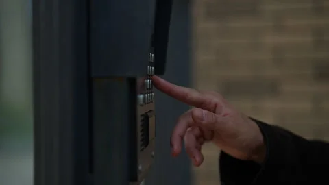 Close-up hands of unrecognizable man ringing intercom system standing on urban Stock Footage 296582105