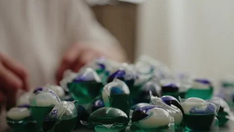 Close-up hands of unrecognizable man sorting through pile of colorful laundry Stock Footage 313717125