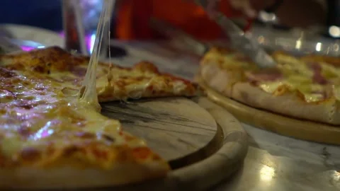 Close-up hands of unrecognizable man taking slice of small pizza table with Stock-Footage 336586672