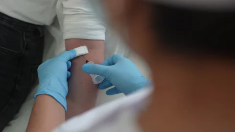 Close-up hands of unrecognizable nurse putting piece of alcohol cotton wool on Stock Footage 247131765